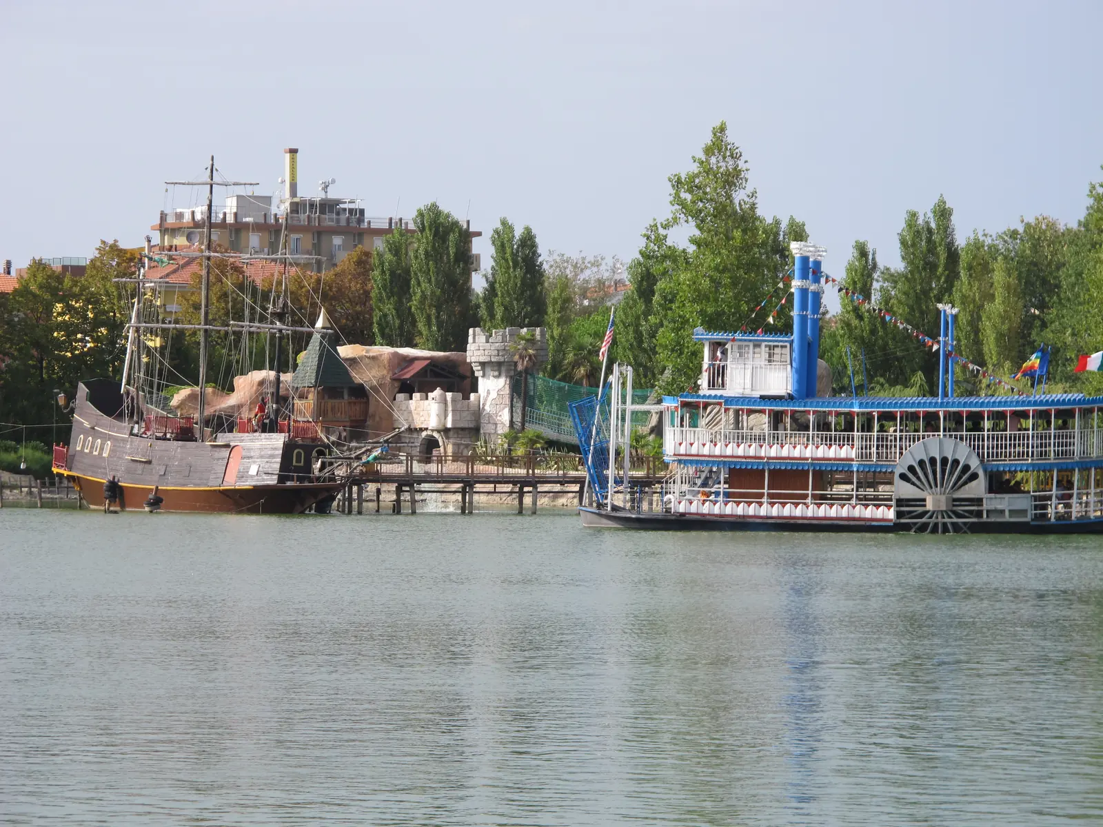Il galeone dei pirati e il battello a ruota ormeggiati sul lago di Fiabilandia, fra alberi e torri finte