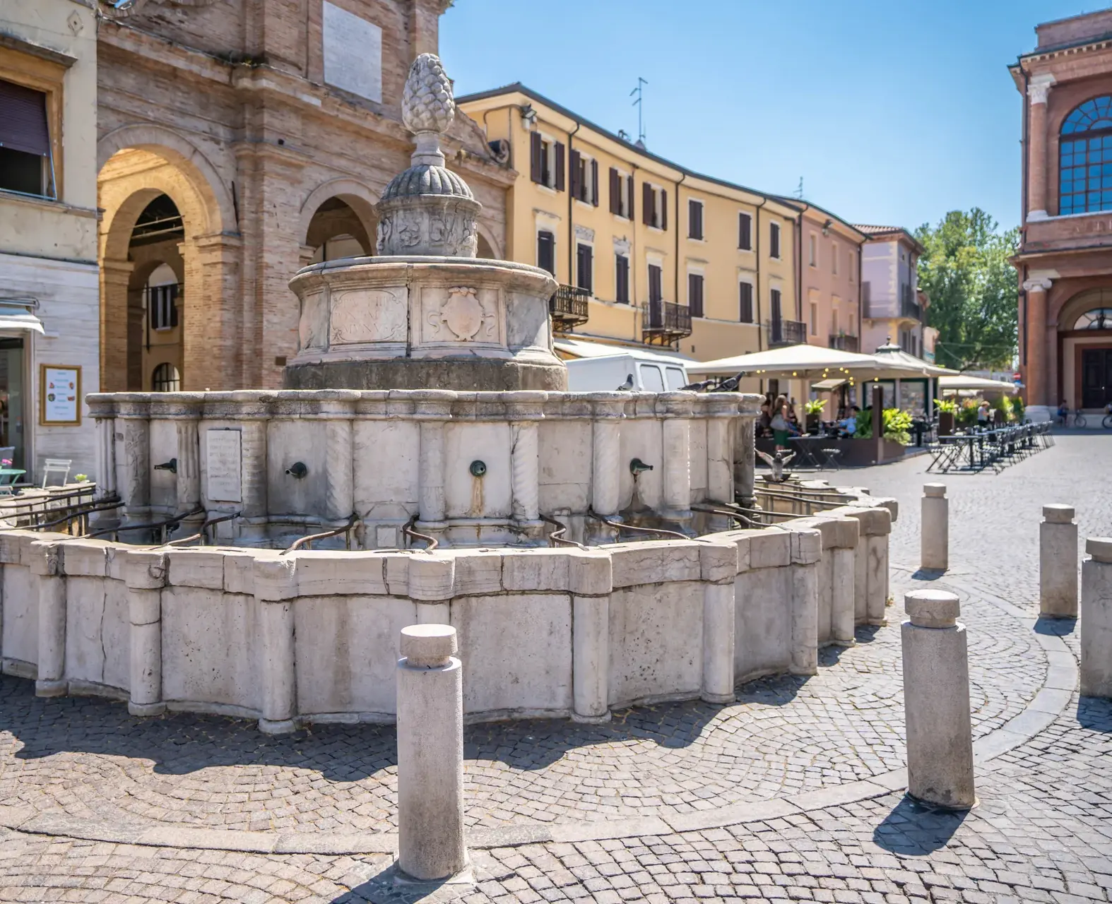 La Fontana della Pigna in piazza Cavour, con la vasca in marmo, le colonnine attorno e la pigna in cima