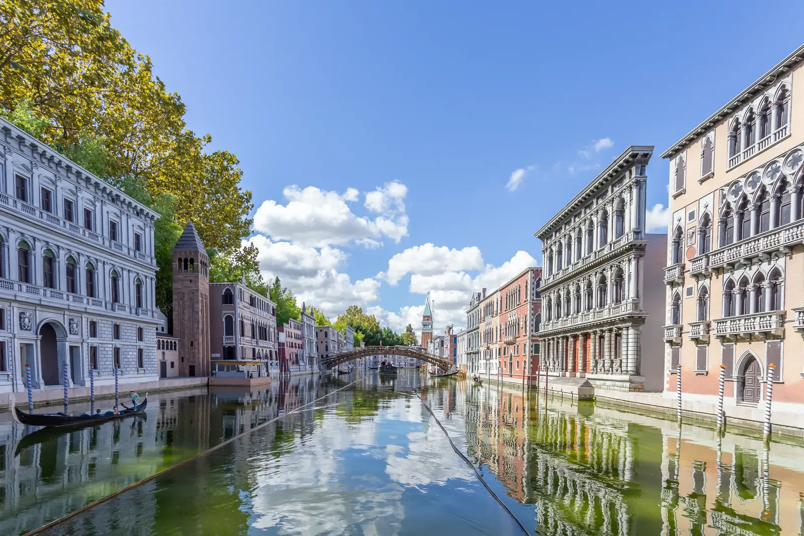 Un canale di Venezia in miniatura, con i palazzi riflessi nell'acqua, una gondola e un ponte sullo sfondo