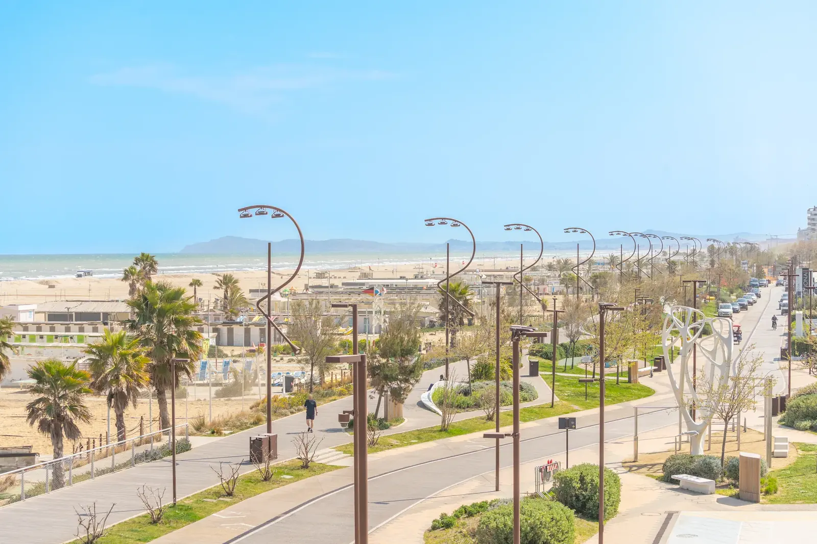 Il Parco del Mare sul lungomare di Rimini visto dall'alto, con i lampioni ricurvi, la pista ciclabile e la spiaggia
