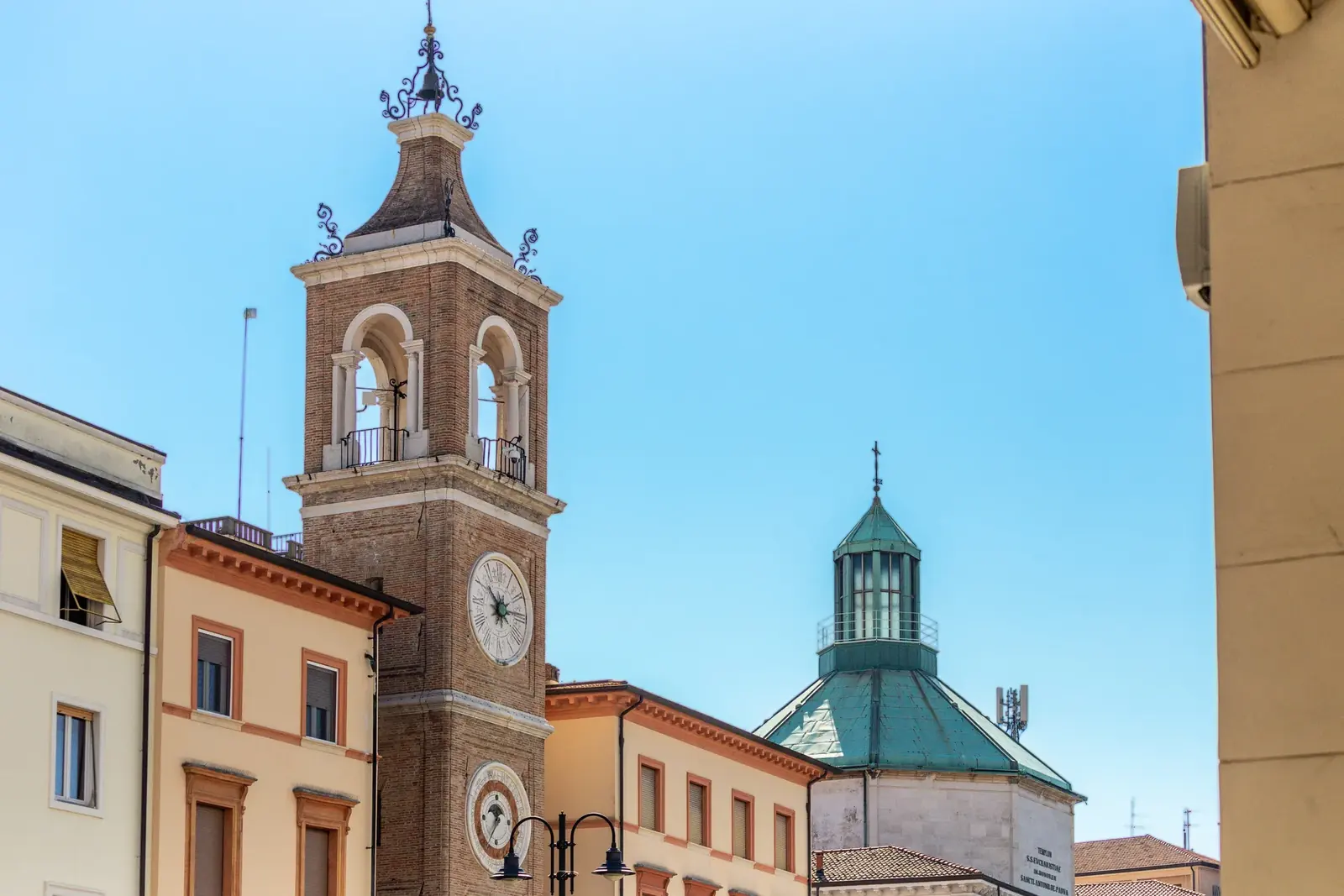 La Torre dell'Orologio di piazza Tre Martiri, con i due quadranti, e la cupola verde del tempietto di Sant'Antonio