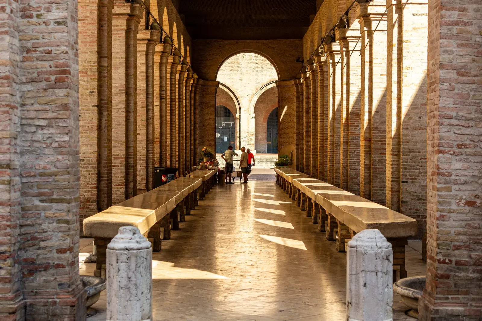 La loggia della Vecchia Pescheria di Rimini, con i banchi in pietra allineati sotto le arcate in mattoni